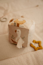 Cube d'activités bébé beige tenu par un bébé